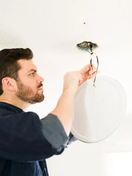 Electricista instalando un punto de luz de iluminación de techo