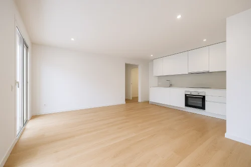 Reforma integral de piso con cocina abierta y salón vacío en Mollet del Vallès Interior reformado de un piso en Mollet del Vallès con cocina blanca abierta y salón diáfano con suelo de parquet